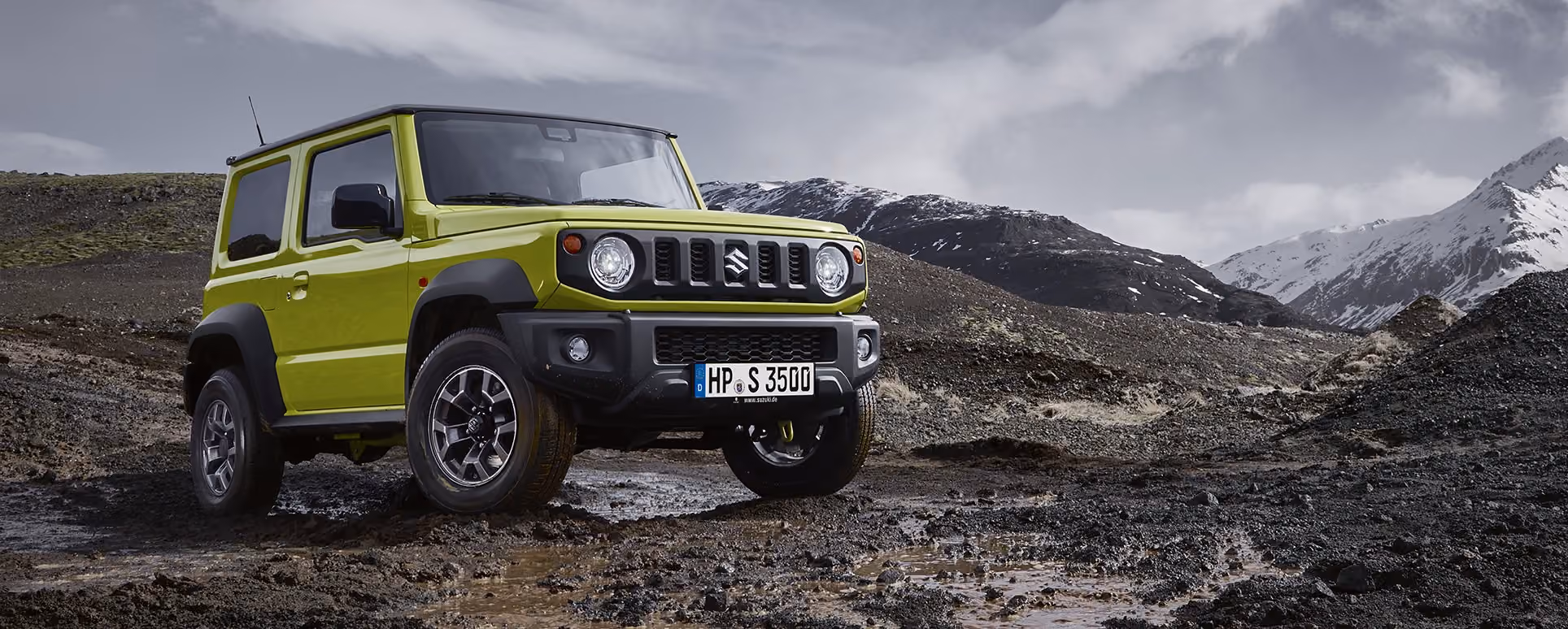 Abblidung zeigt einen grünen Jimny, der auf steinigem Untergrund auf einem Berg fährt