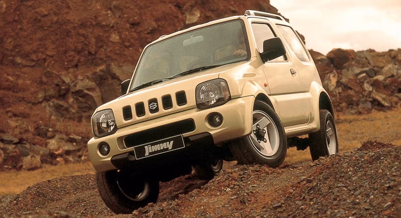 Abbildung zeigt einen weißen Jimny, der einen steilen Hang hinunter fährt