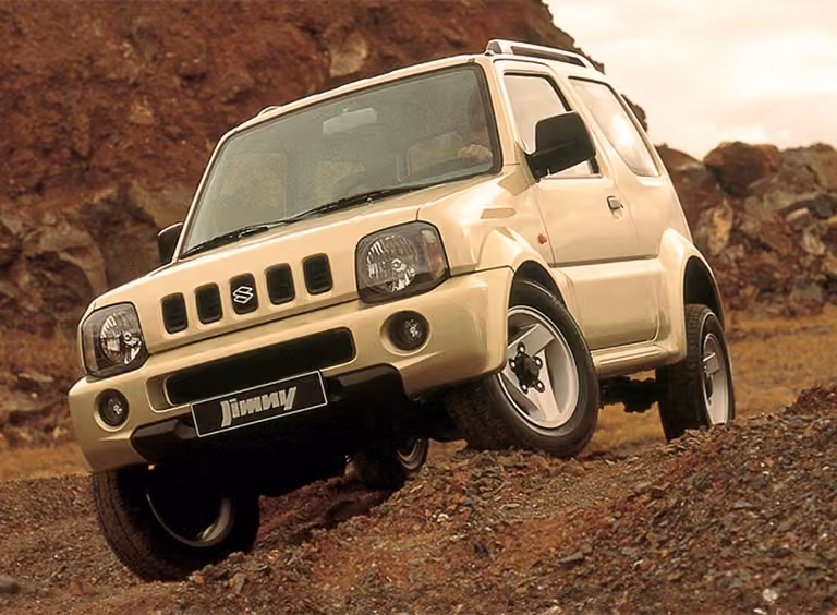Abbildung zeigt einen weißen Jimny, der einen steilen Hang hinunter fährt